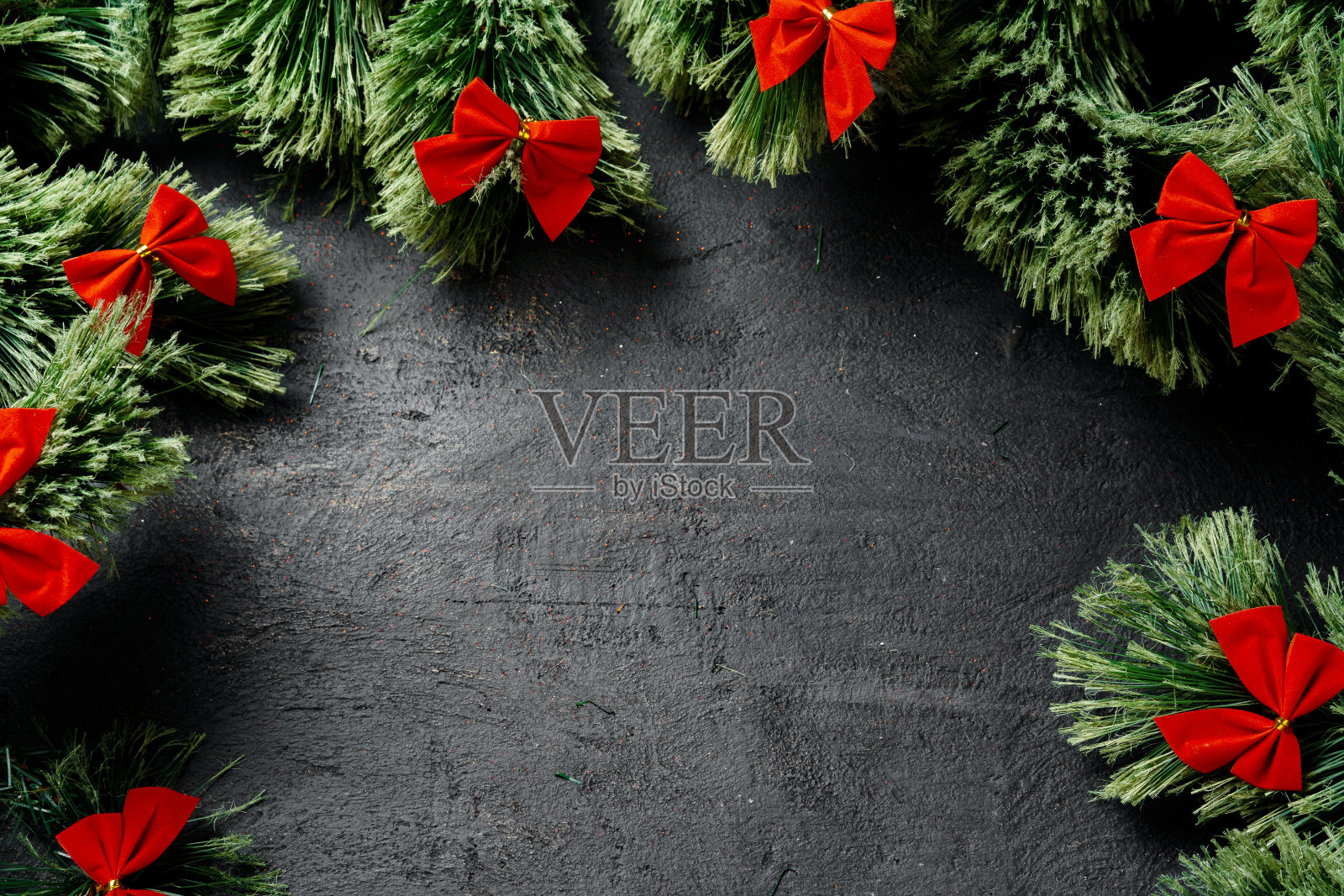 圣诞背景与适合的树枝和红色丝带在黑色照片摄影图片