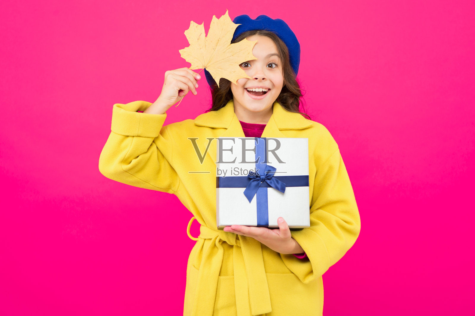秋天的礼物。“黑色星期五”。小女孩秋装红色背景。小女孩和礼盒。孩子抱着秋天的枫叶。孩子得到礼物。秋天的购物。季节性出售。收到,谢谢照片摄影图片