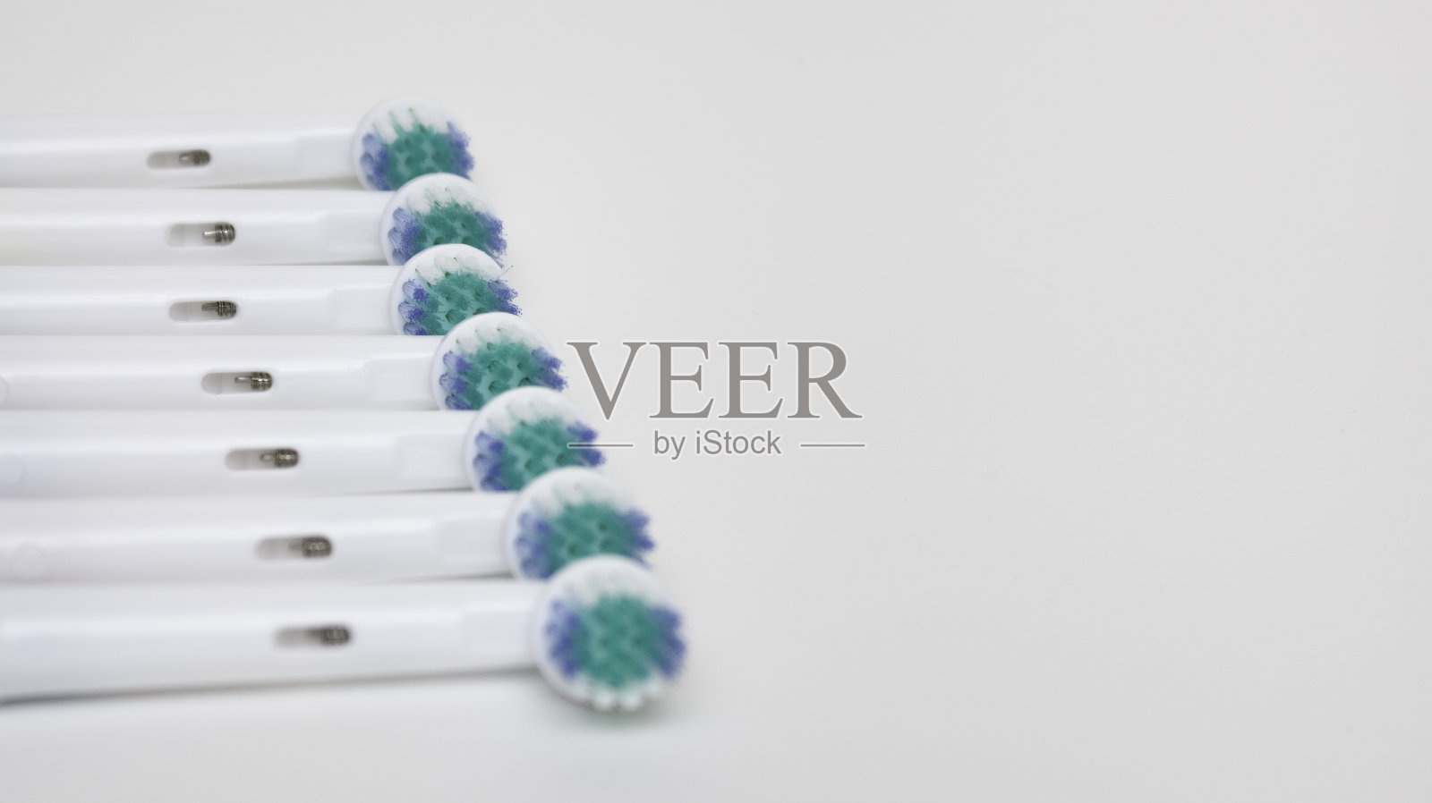 电动牙刷的零件排成一排，白色背景，留出文字空间。照片摄影图片