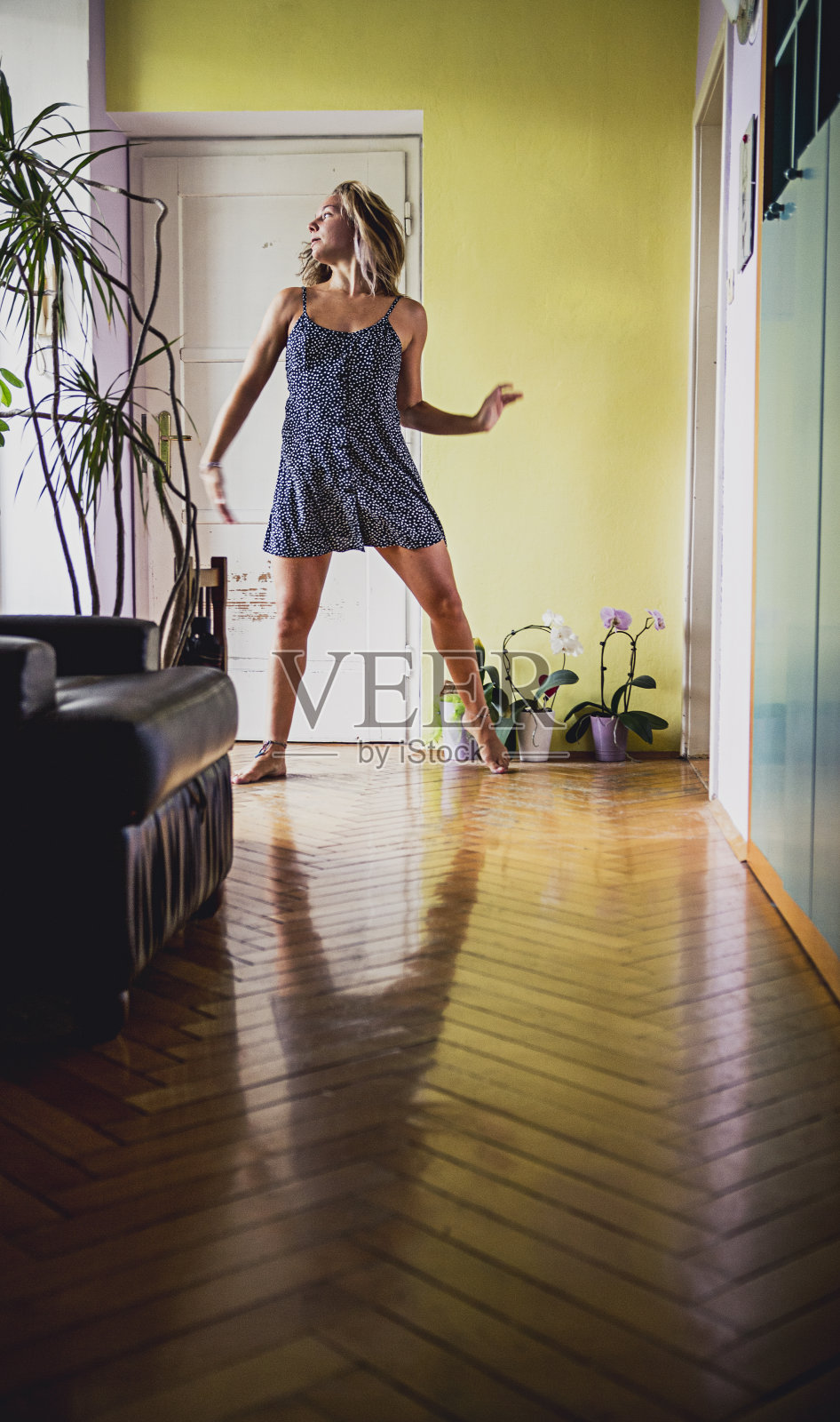 一个年轻女子在她的公寓里跳舞照片摄影图片