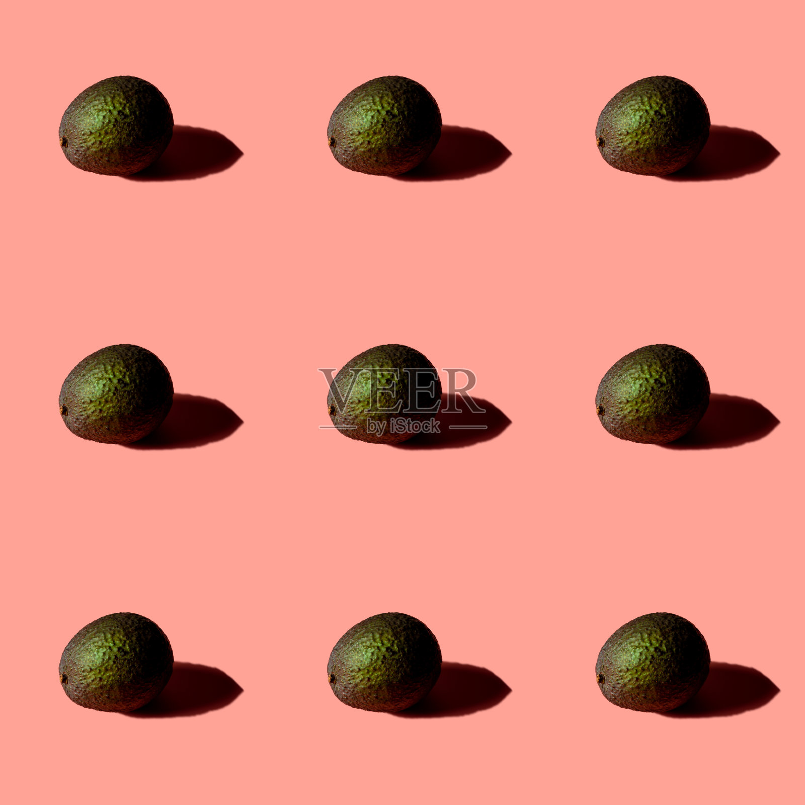 粉红色背景上的新鲜成熟的牛油果。照片摄影图片