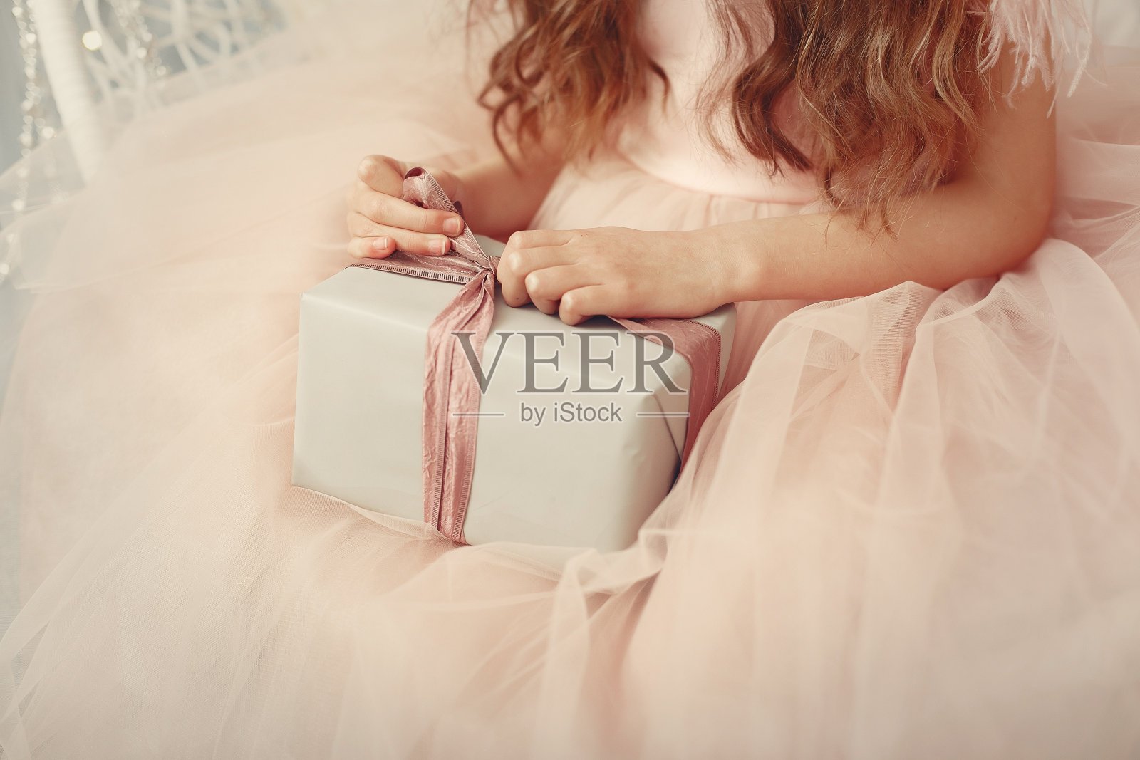 小女孩在圣诞树旁穿着粉红色的裙子照片摄影图片