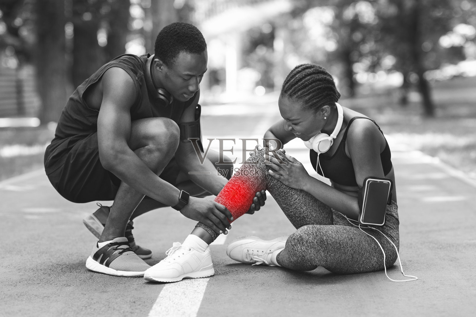 培训期间的创伤。非洲妇女在慢跑后扭伤脚踝，BW射击照片摄影图片