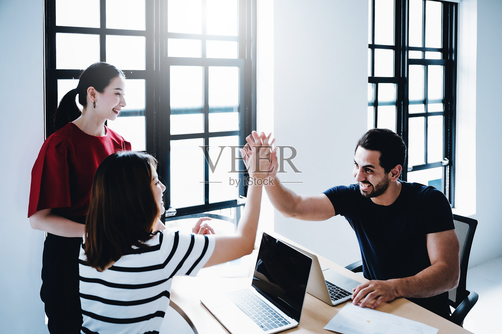 成功的企业家和商业人士实现目标。快乐的企业团队给予击掌手势，他们笑着，为他们的成功欢呼，图像运动模糊技术照片摄影图片