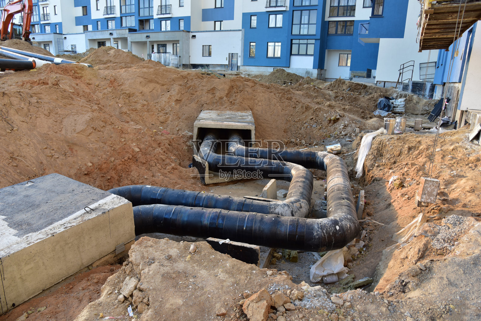 在建筑工地的地沟内敷设暖气管。安装水管和卫生下水道的地下防雨系统。公寓的冷热水、供暖和采暖系统照片摄影图片