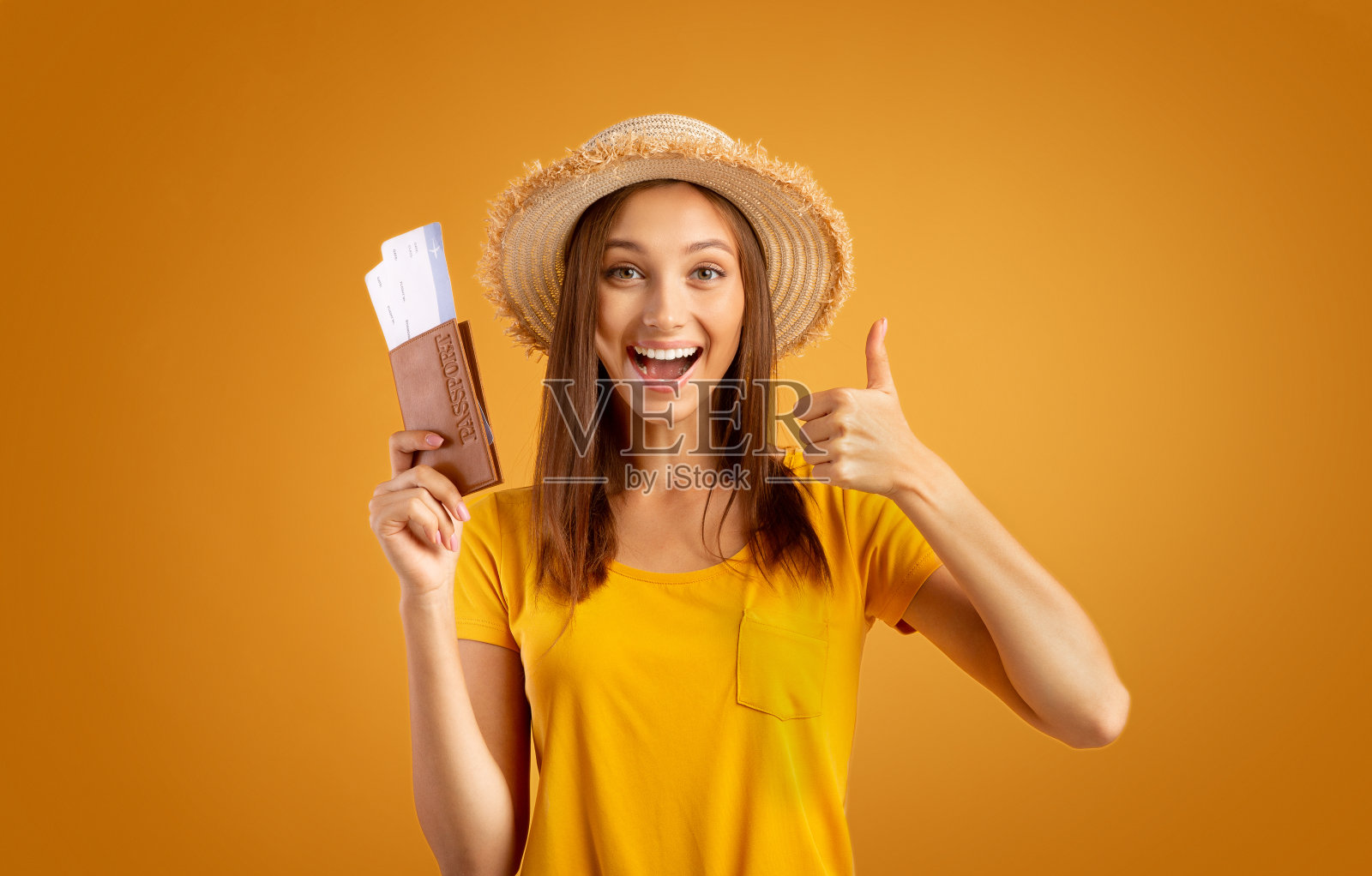 情绪激动的女旅行者，拿着护照竖起大拇指照片摄影图片