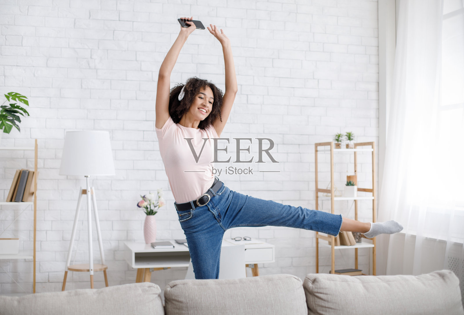 非洲裔美国女孩唱着最喜欢的歌曲，戴着耳机听音乐照片摄影图片