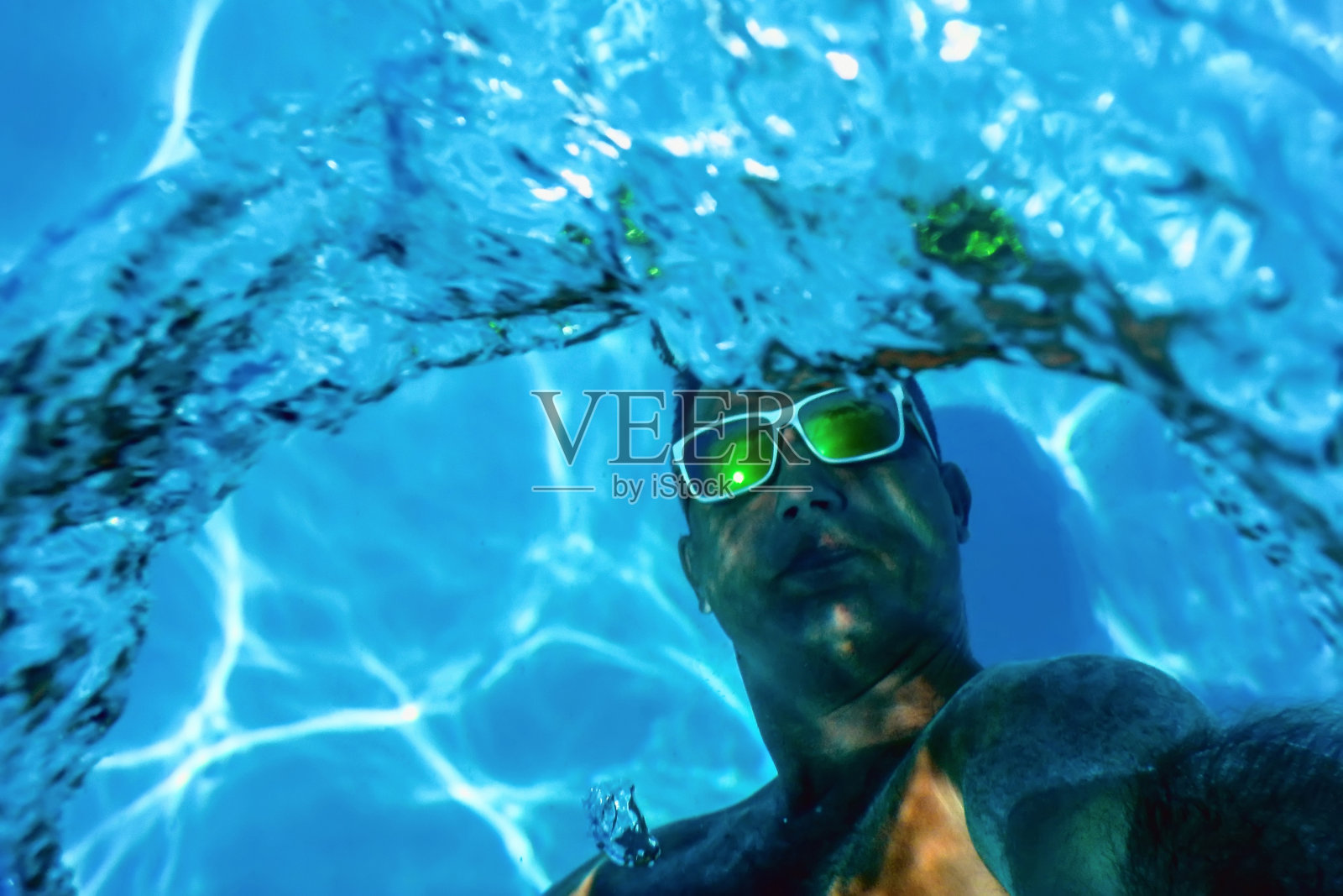 游泳池夏季派对，男人在游泳池水下制造泡泡环照片摄影图片