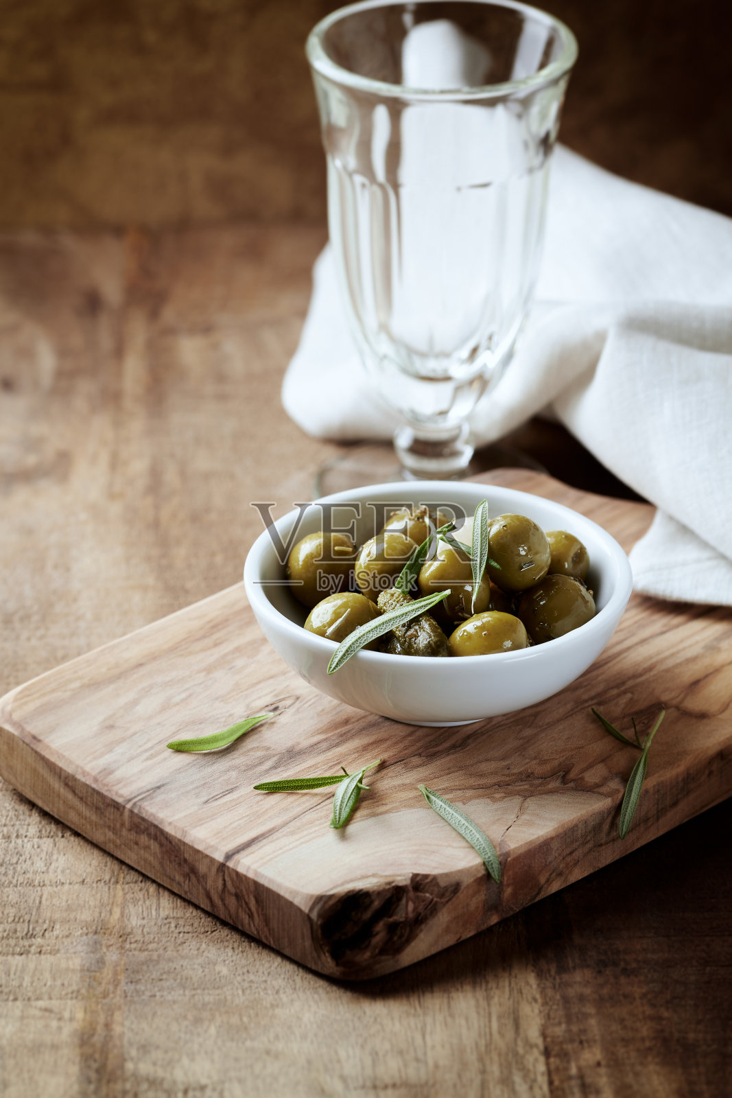 绿色的橄榄在质朴的木头背景上。照片摄影图片