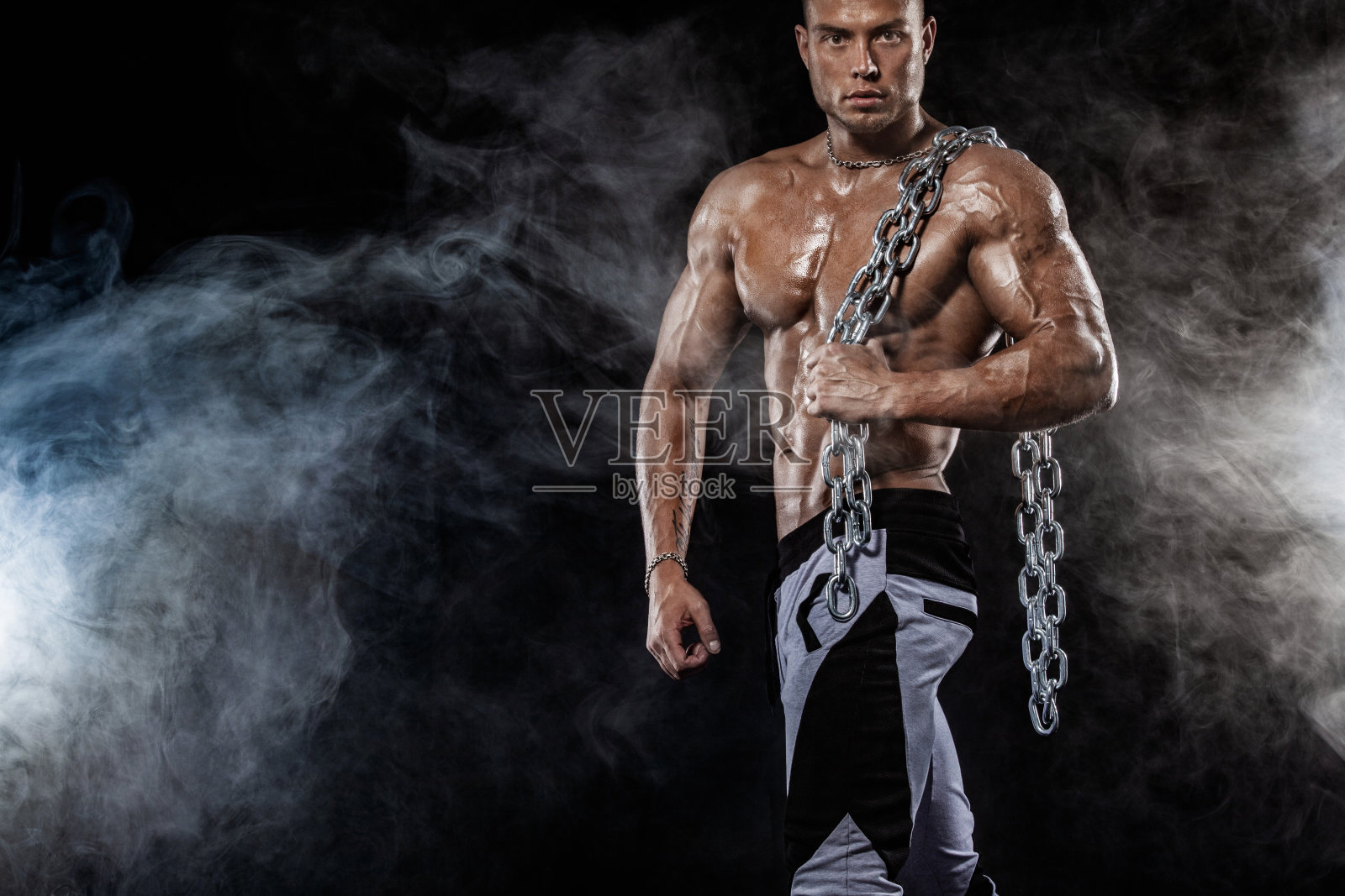 现场进行健美比赛。男子运动员体格和运动员。黑色背景和灯光。照片摄影图片