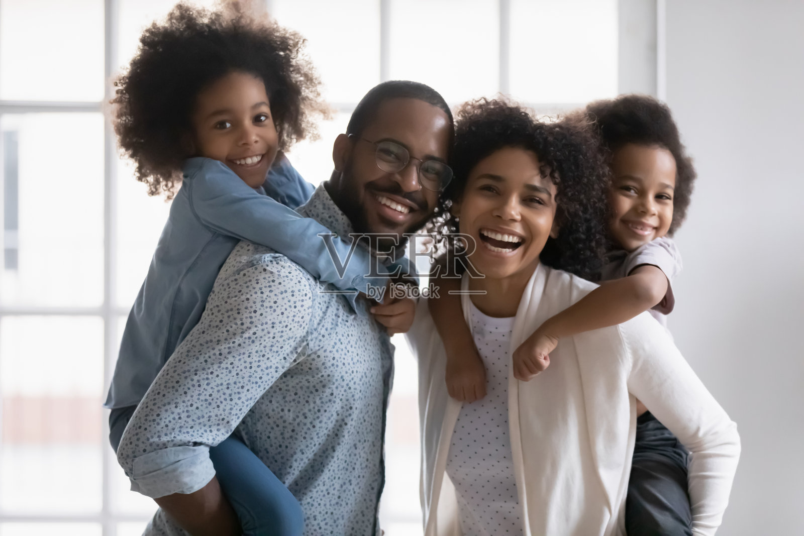 快乐的混血儿年轻夫妇父母给孩子骑在背上。照片摄影图片