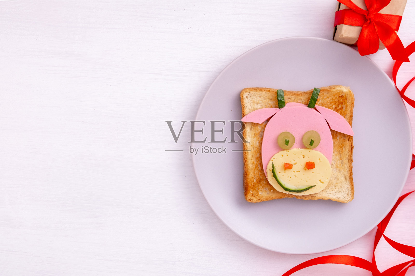 有趣的三明治，用吐司面包、香肠和奶酪制成的可食用的2021牛象征。给孩子们的早餐点子。新年圣诞美食俯视图。节日、庆典、美食艺术照片摄影图片