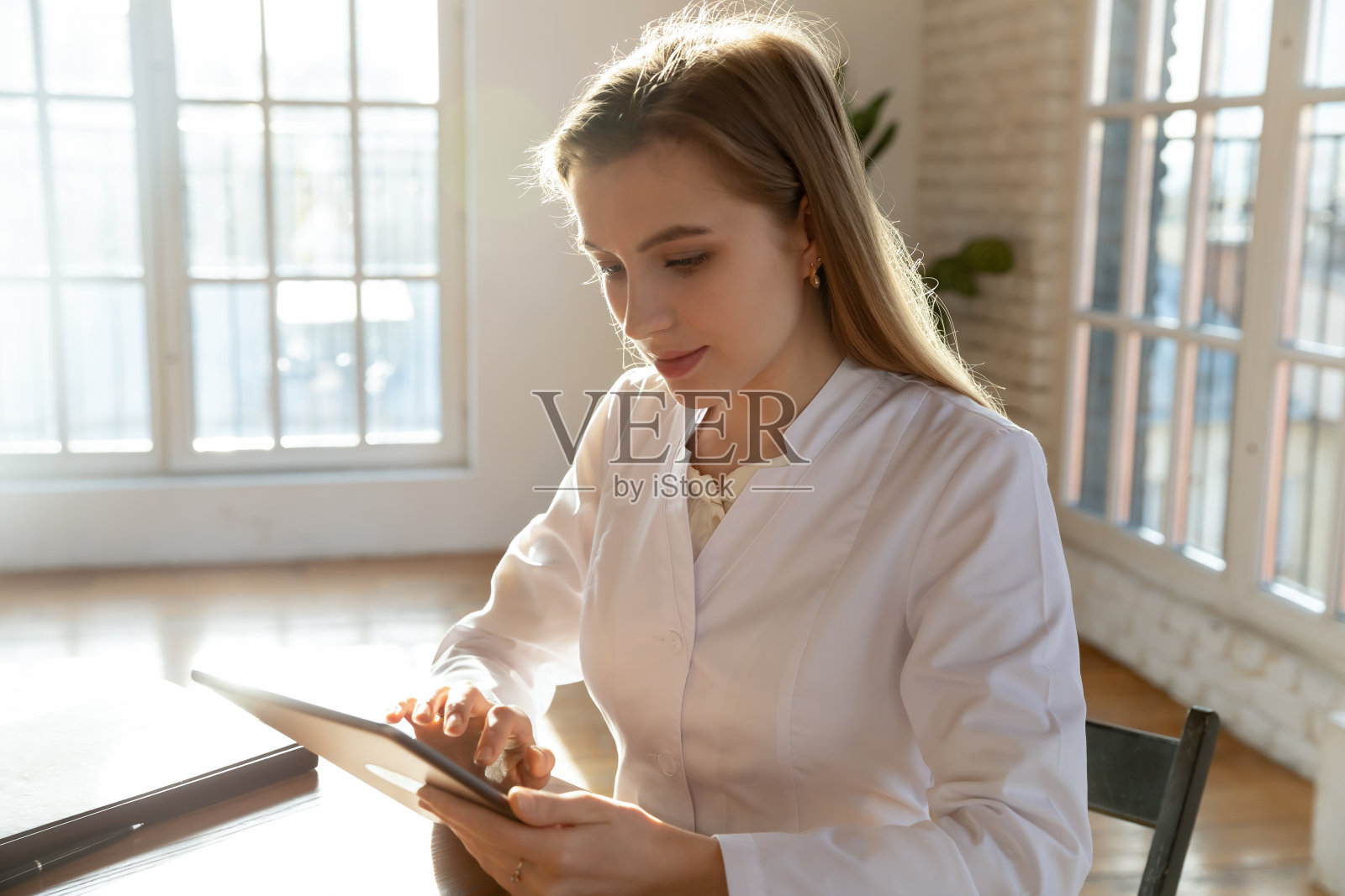 专注于在办公室在线平板电脑的年轻女医生照片摄影图片