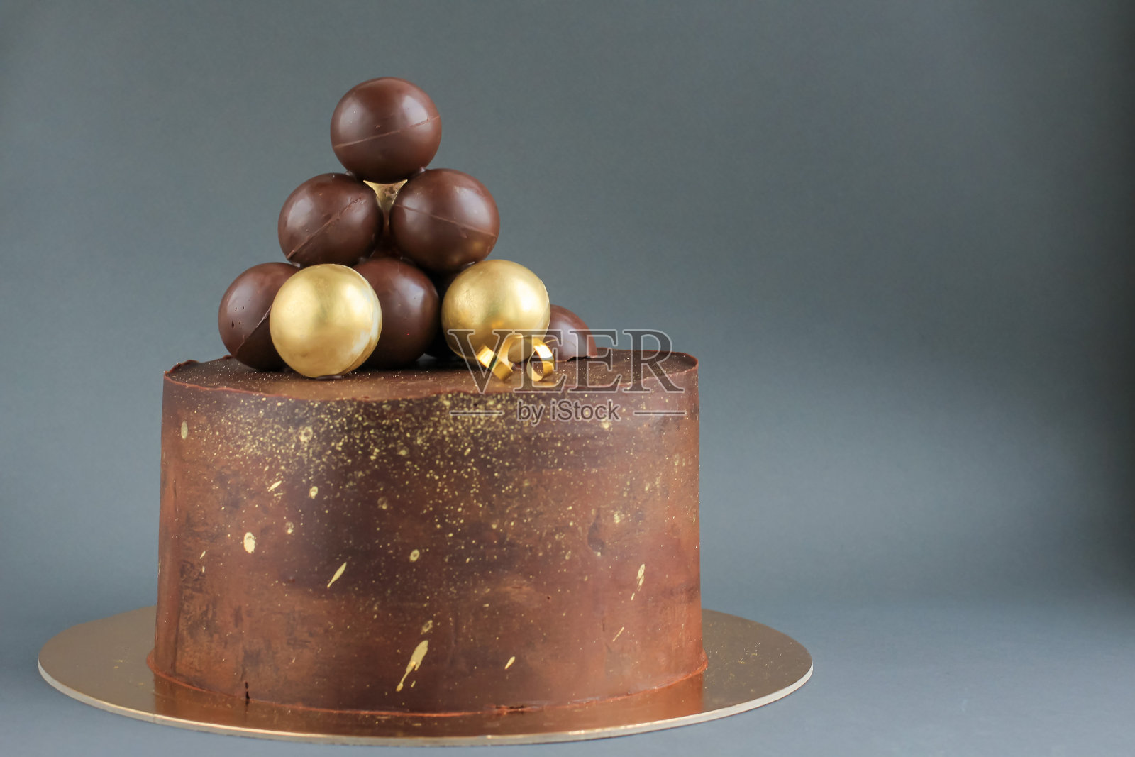 金色装饰的巧克力生日蛋糕。节日，庆祝，时尚，简约的概念。照片摄影图片