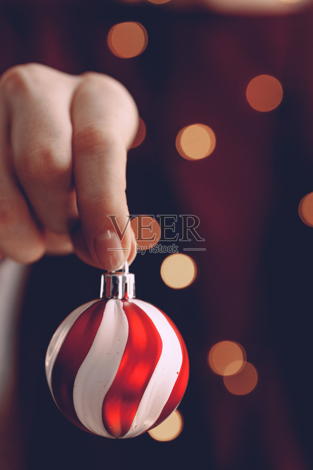 女人手里拿着圣诞球凑近了照片摄影图片