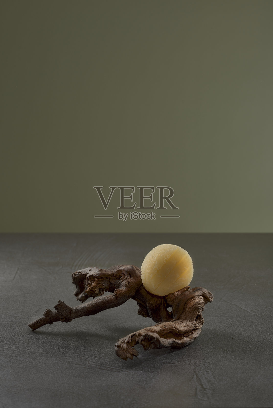 黑泽奶酪或手奶酪在藤蔓高汤上，深灰色的石头表面，绿色背景照片摄影图片