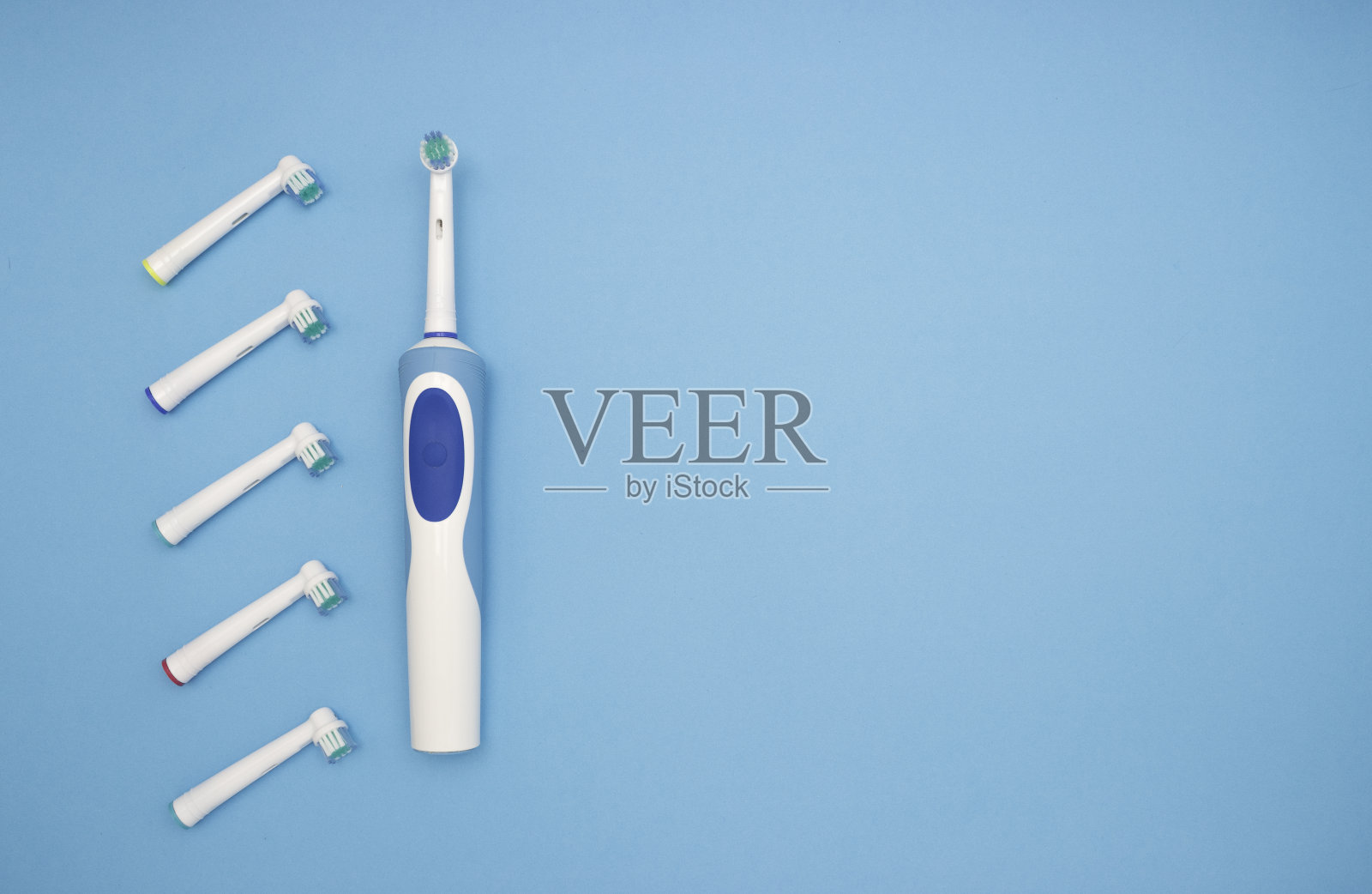口腔卫生。蓝色背景上的电动牙刷和替换刷。从上往下看。照片摄影图片