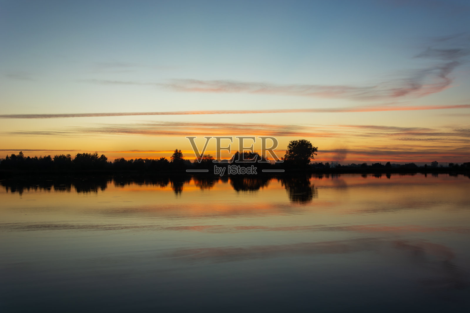 日落后，云朵倒映在湖水中照片摄影图片