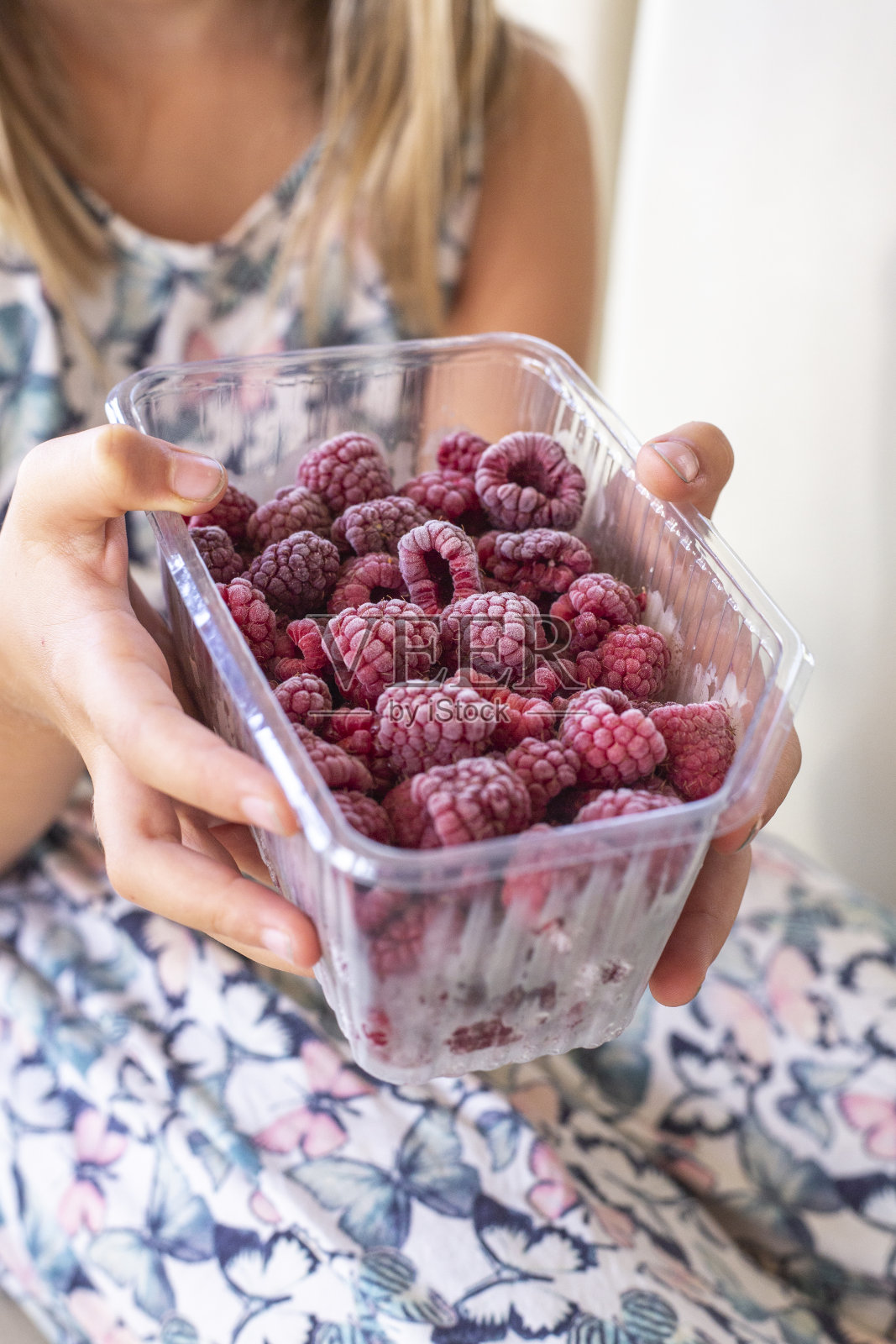 女孩拿着冰冻的覆盆子照片摄影图片