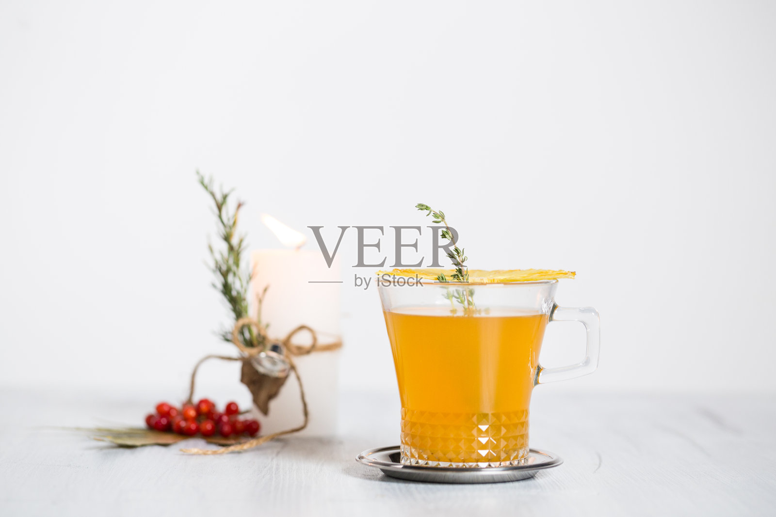 鸡尾酒、蜡烛和玫瑰果枫叶的静物画。照片摄影图片