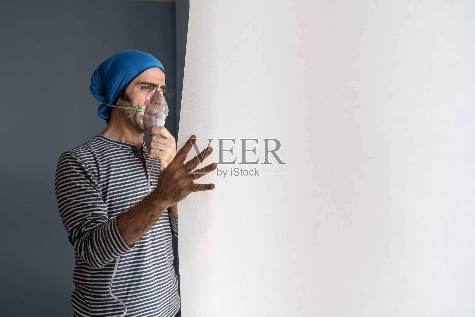 中年男人使用雾化器并望向窗外照片摄影图片