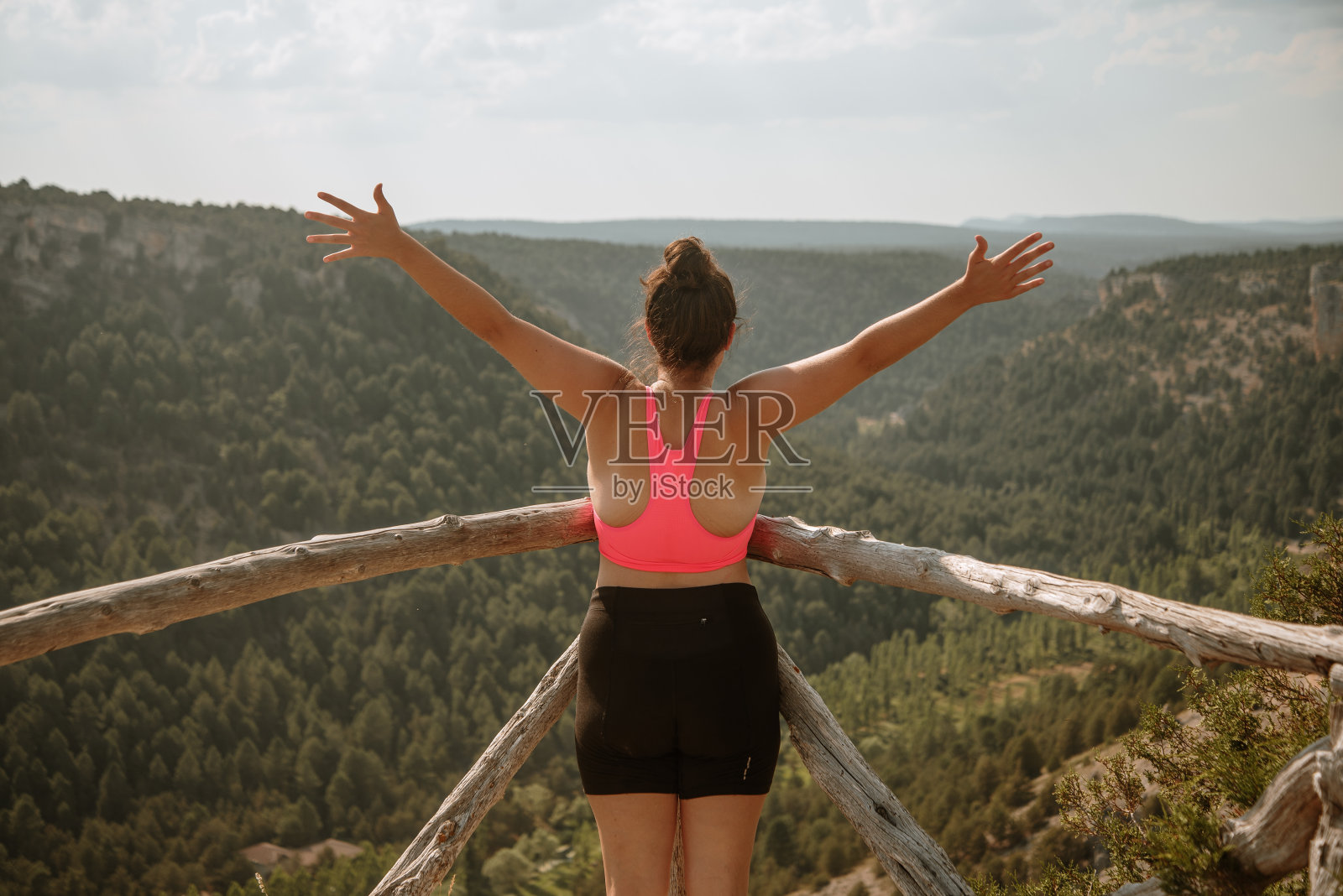 在山顶上举起双手的年轻女子照片摄影图片