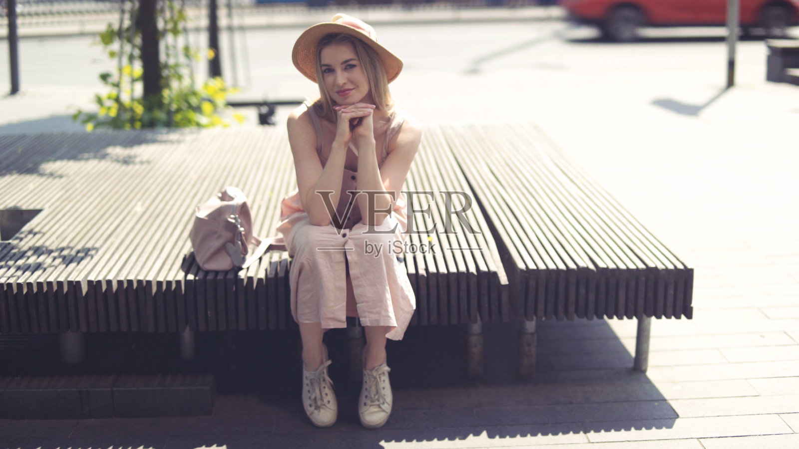 美丽的金发女人的肖像戴着帽子花时间在一个城市。照片摄影图片