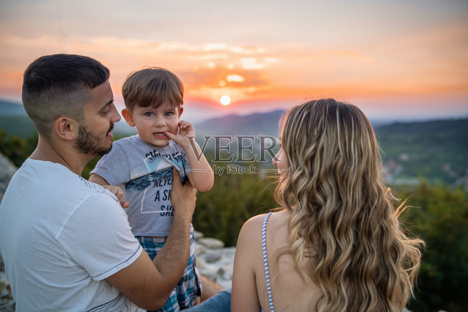 嘴里叼着手指的小孩照片摄影图片