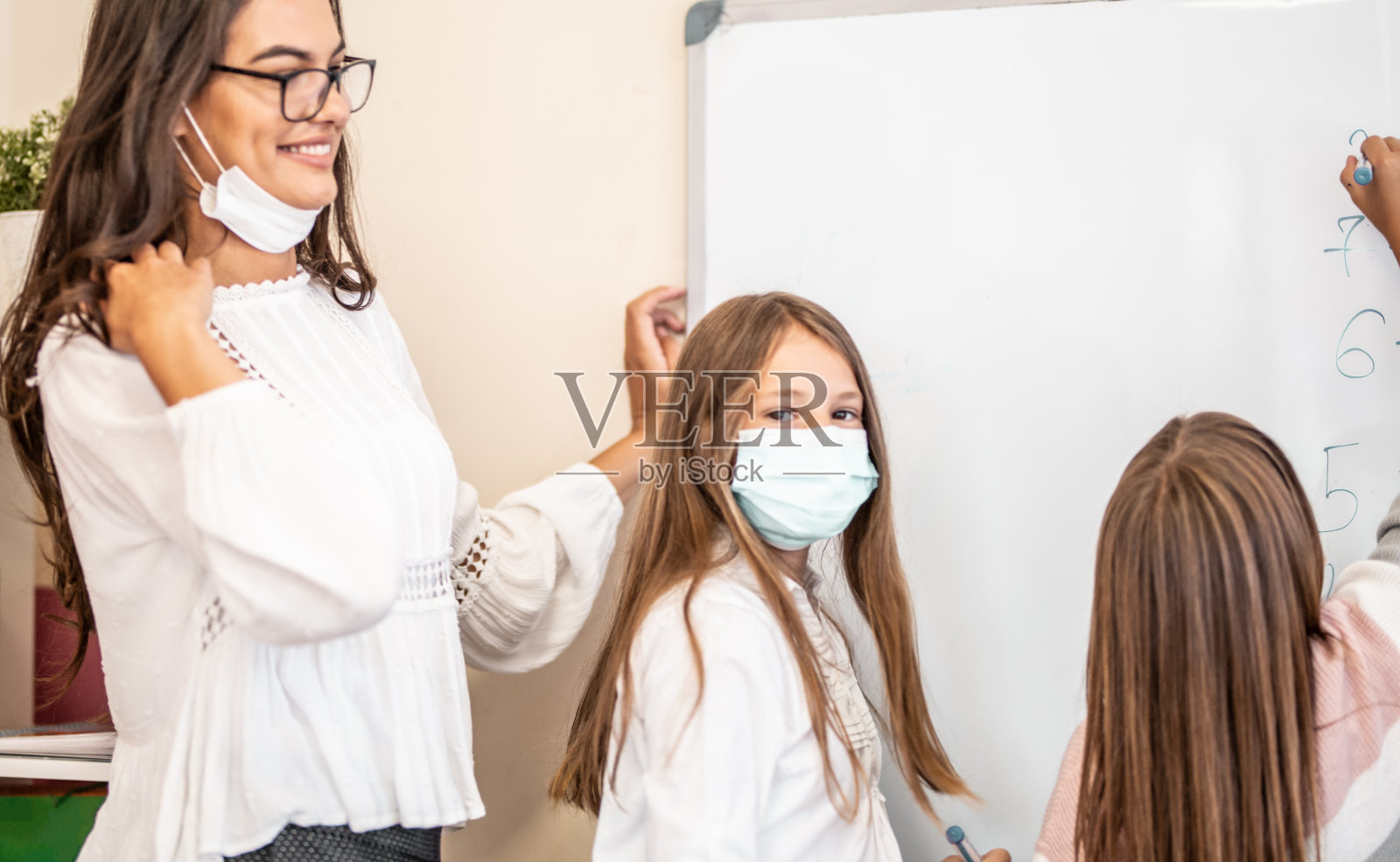 孩子们和他们的老师戴着防护口罩照片摄影图片