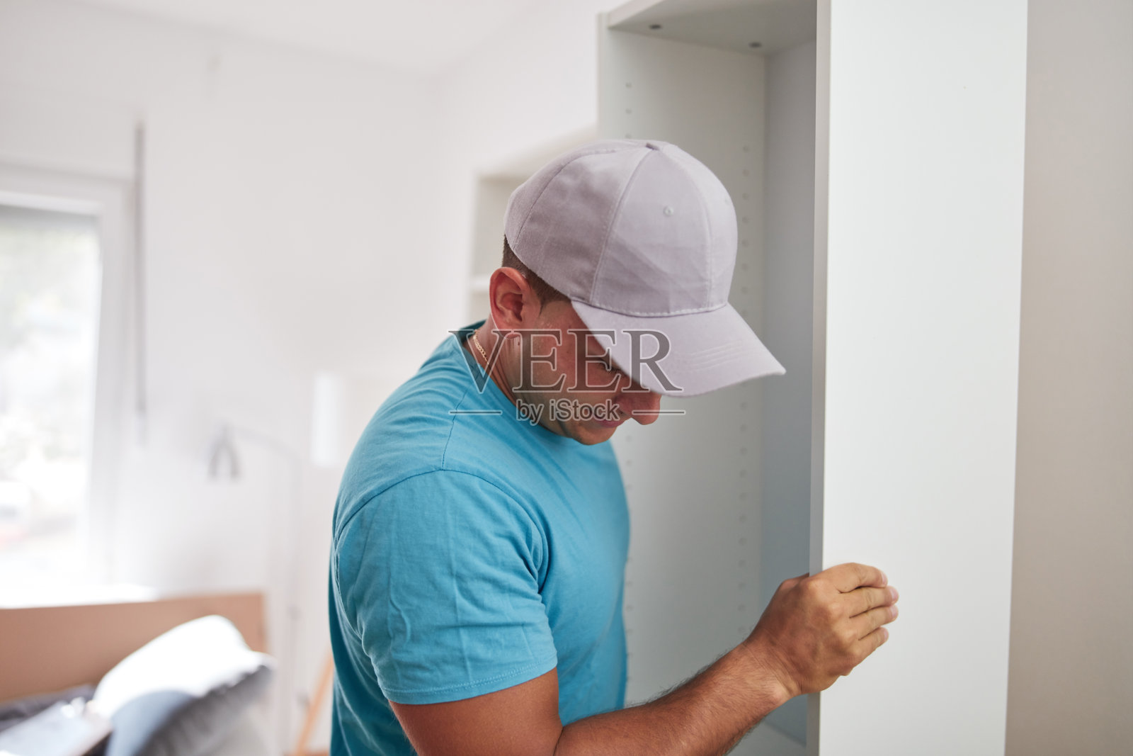 男人在新公寓组装家具，搬进来工作。照片摄影图片