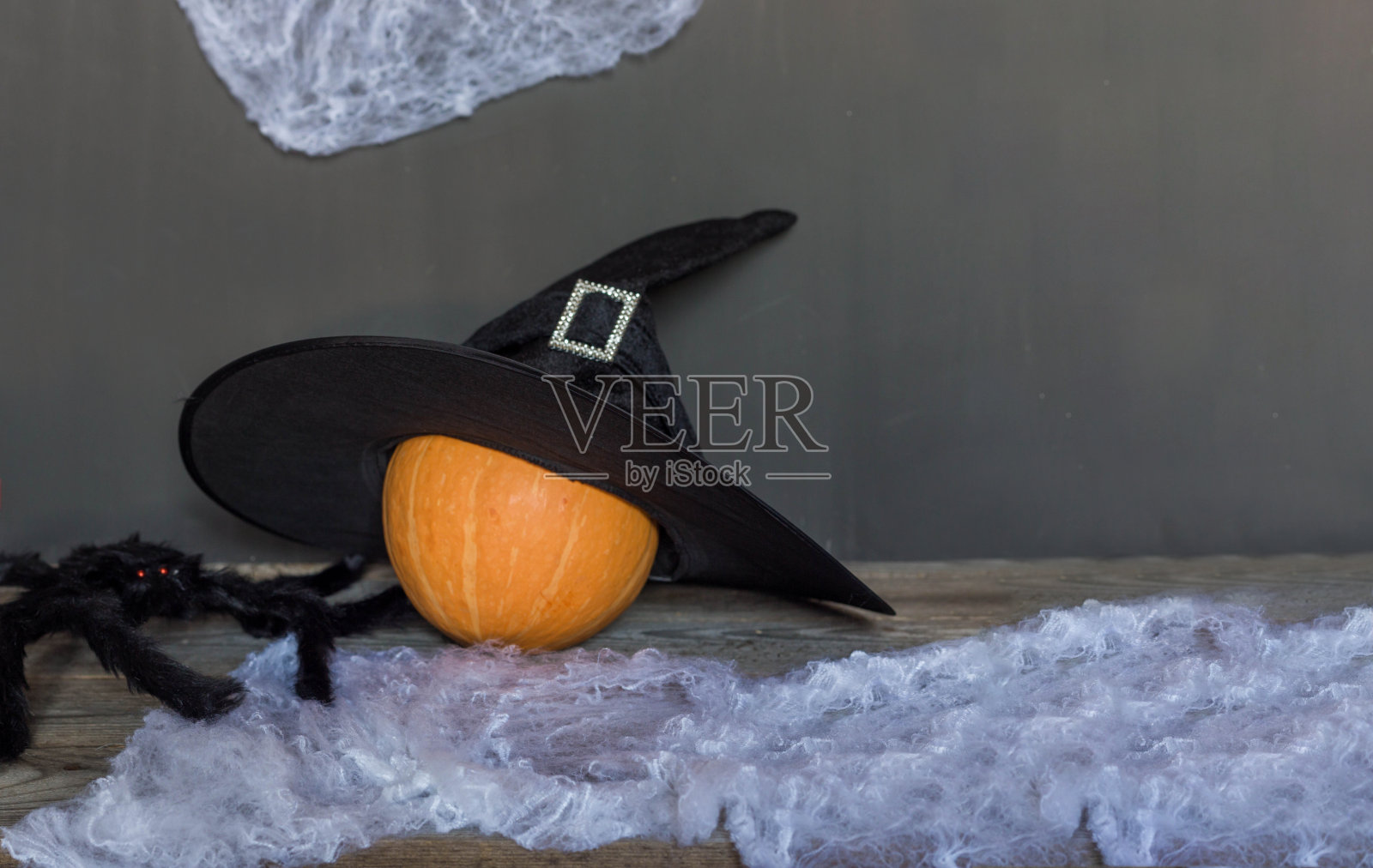 戴着女巫帽的橙色大南瓜，快乐的万圣节背景。照片摄影图片