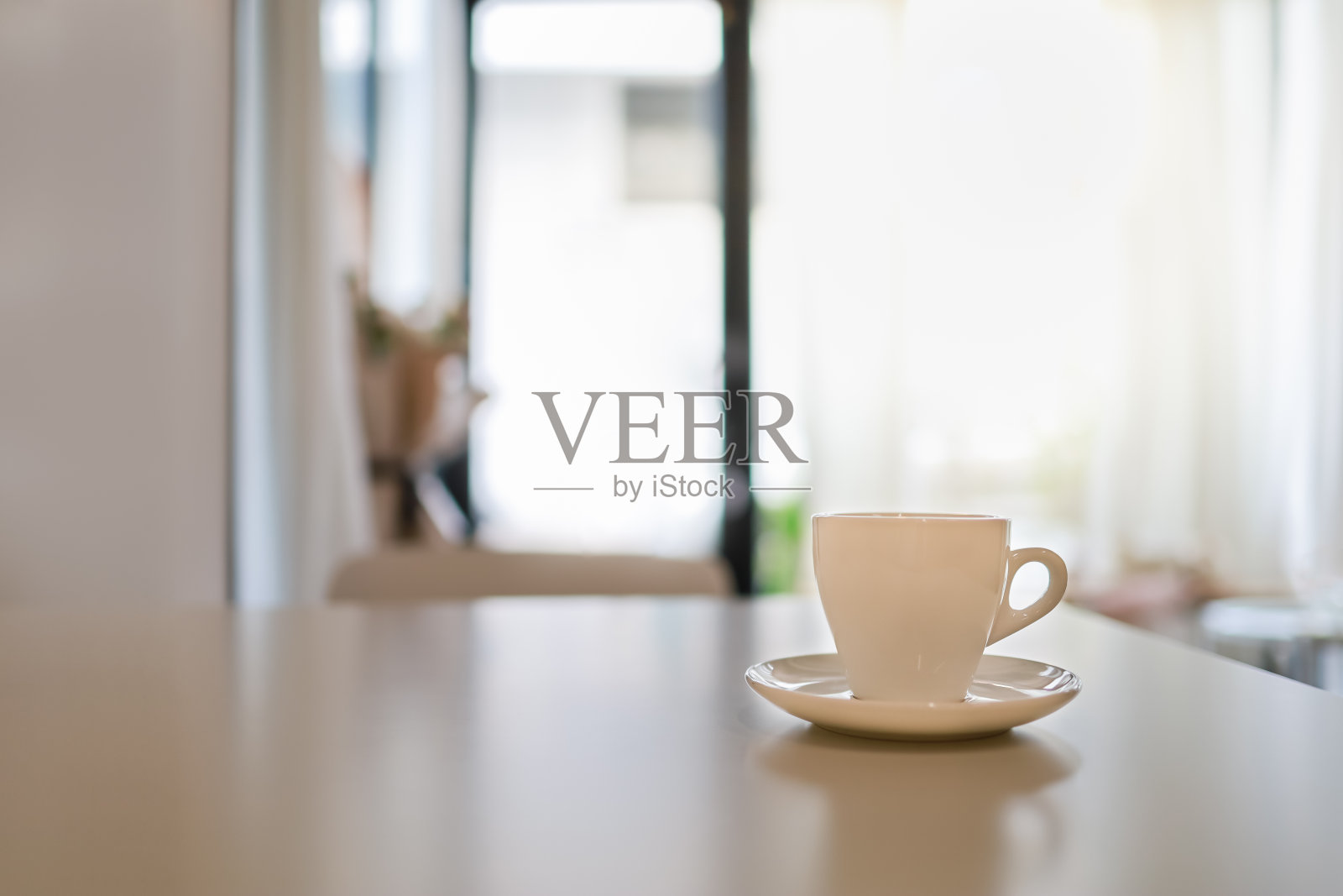 特写的白色杯热咖啡与盘子在一个餐厅的桌子上。照片摄影图片