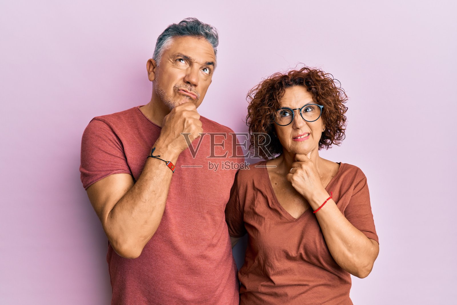 漂亮的中年夫妇一起穿着休闲装思考着一个担心的问题，担心而紧张的手放在下巴上照片摄影图片