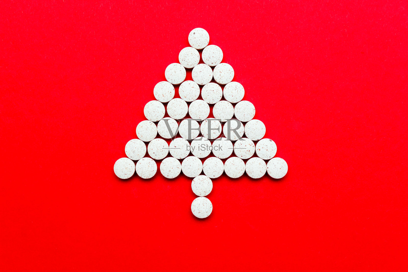 圣诞树上的红色背景药丸照片摄影图片