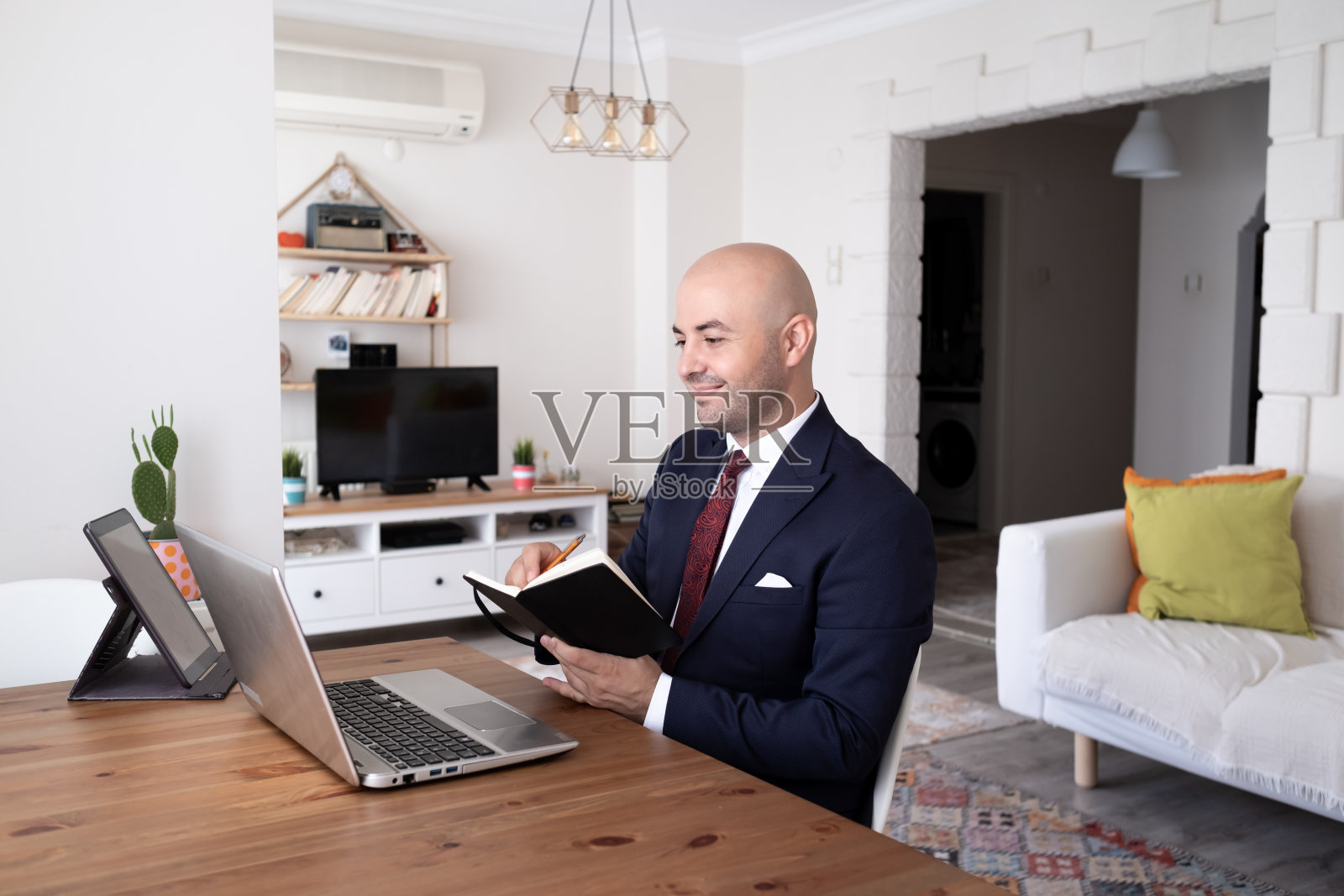 一个年轻人在家远程使用笔记本电脑工作。远程学习。照片摄影图片