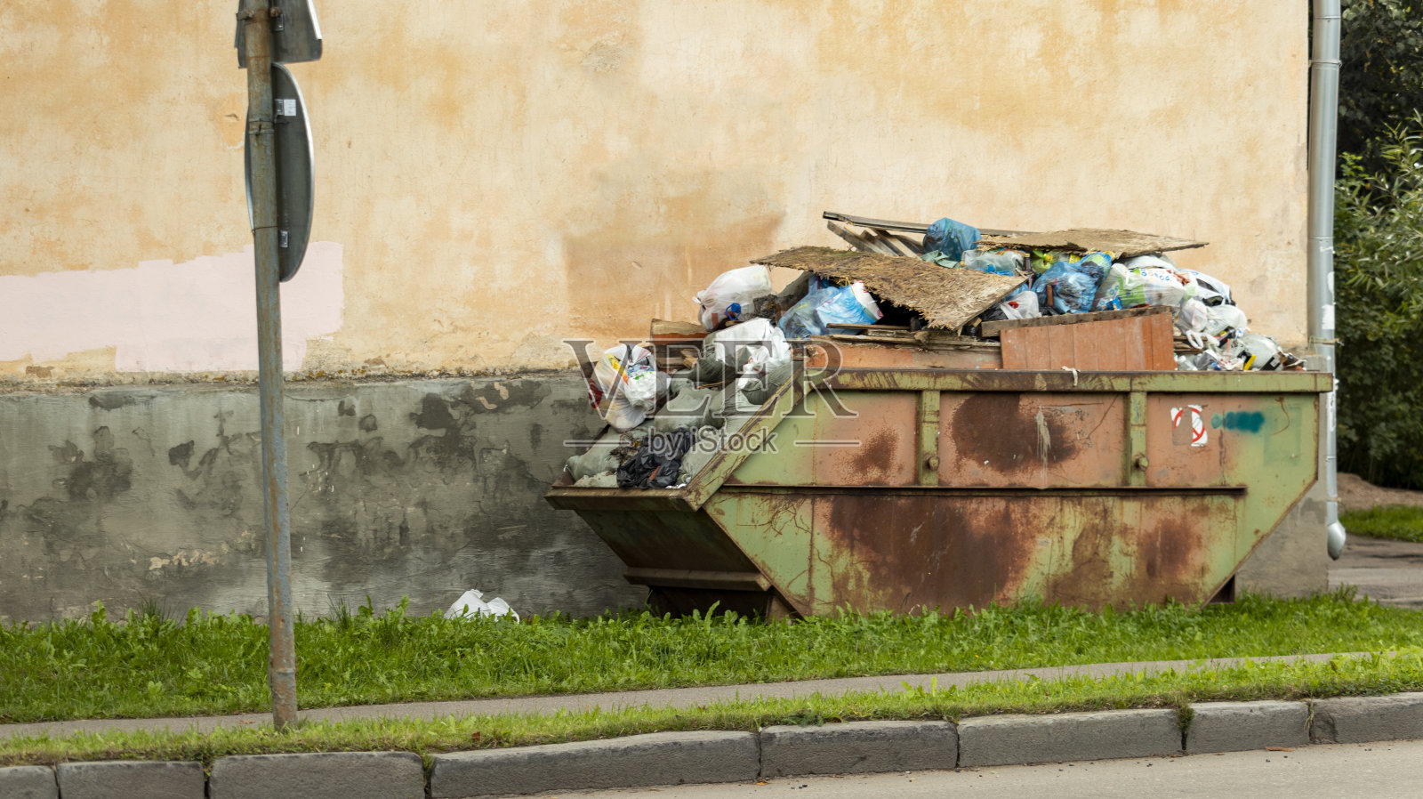 房子附近的垃圾桶里装满了建筑碎片照片摄影图片