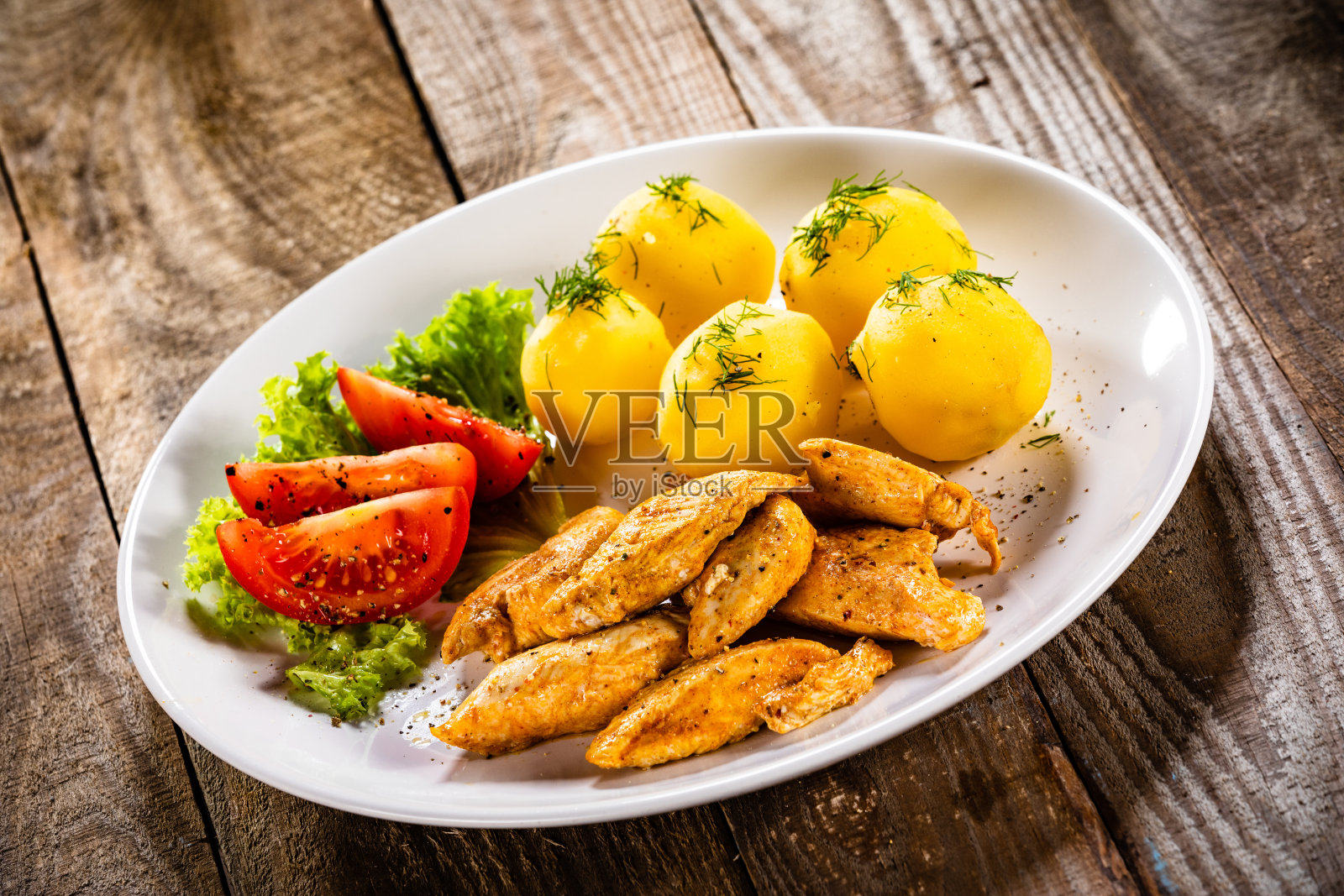 炸鸡块配煮土豆和新鲜蔬菜放在木桌上照片摄影图片
