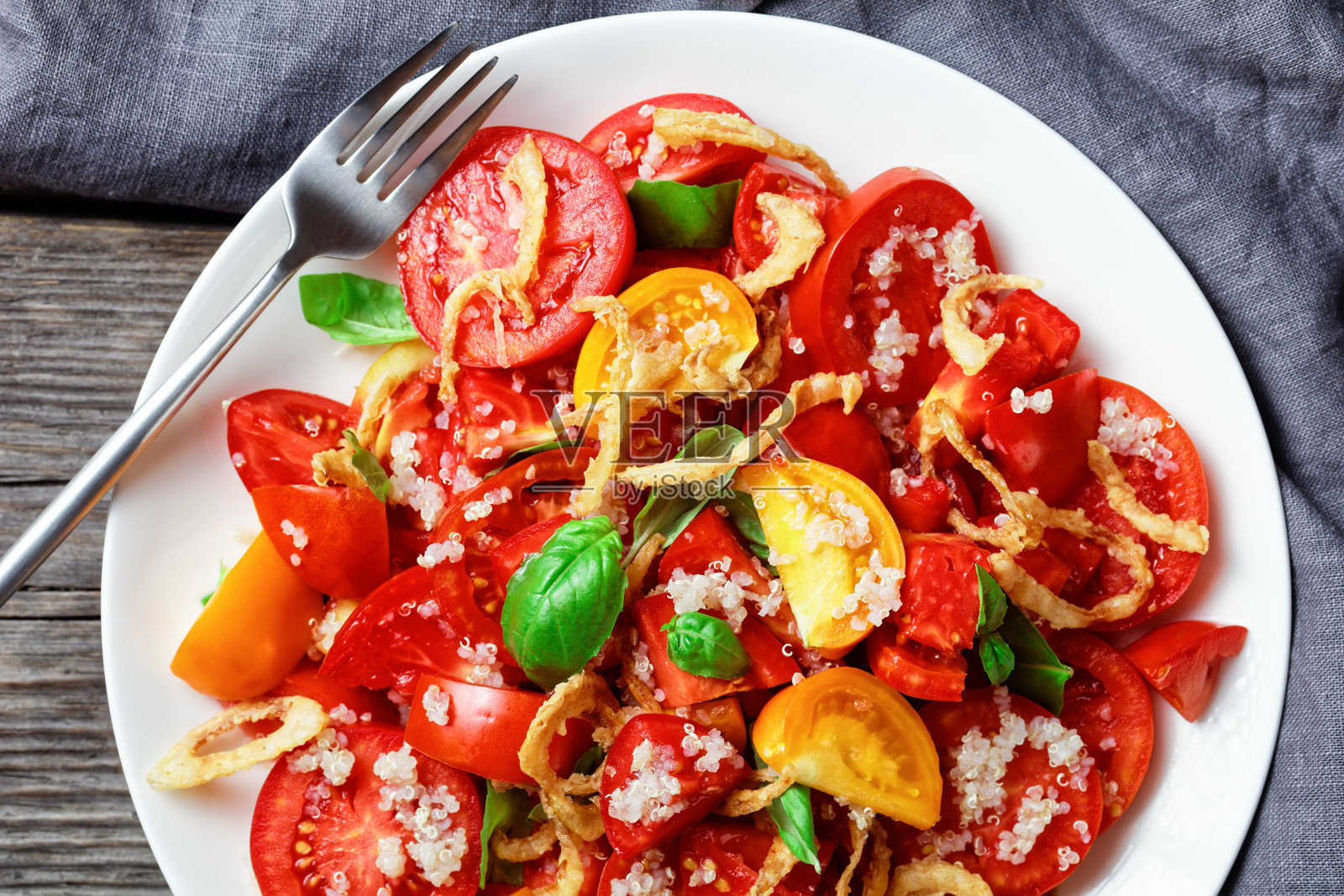 番茄沙拉配脆炸洋葱，藜麦和新鲜罗勒照片摄影图片