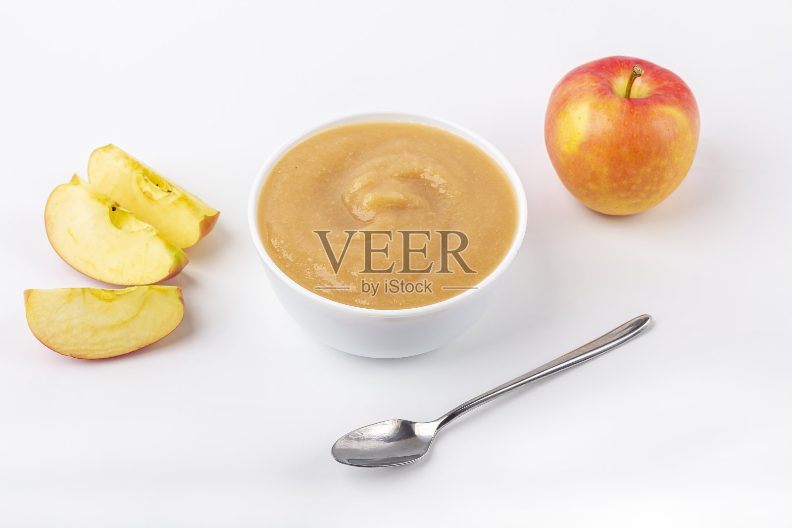 新鲜的自制苹果酱。适当的营养和健康饮食的概念。有机和素食食品。白色碗，布上有水果泥，桌上有切好的苹果。婴儿食品。文本复制空间照片摄影图片