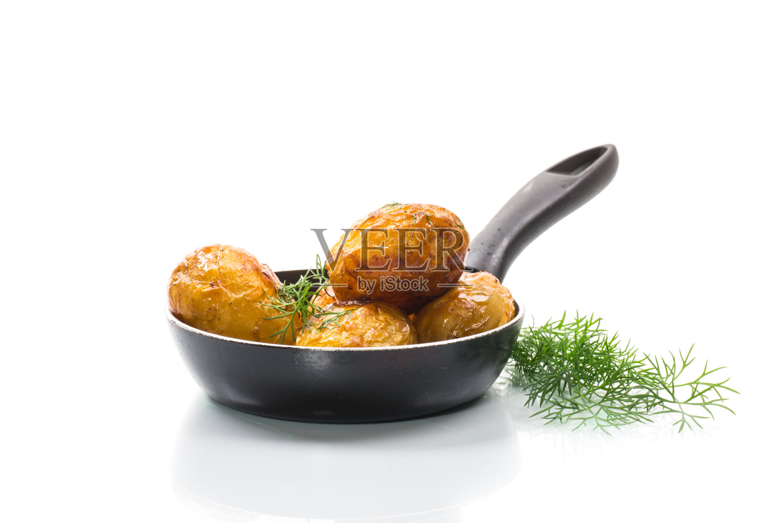 在平底锅里煎整块小土豆照片摄影图片