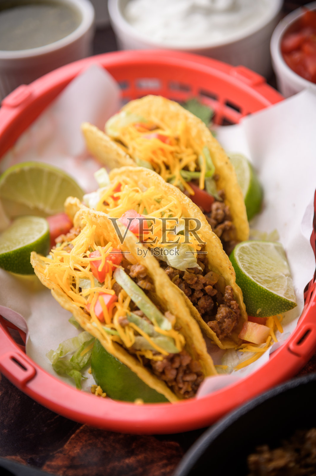 红色塑料篮子里的硬壳玉米卷照片摄影图片