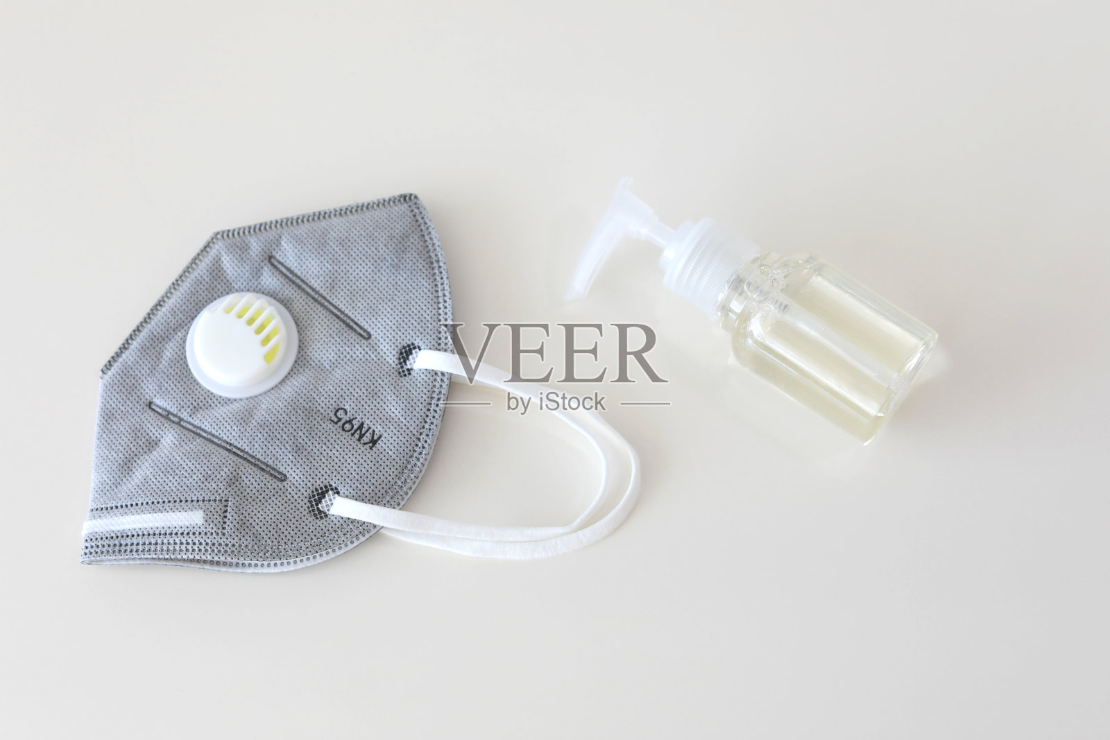 酒精洗手液凝胶瓶与KN95外科口罩。防范COVID-19冠状病毒。照片摄影图片