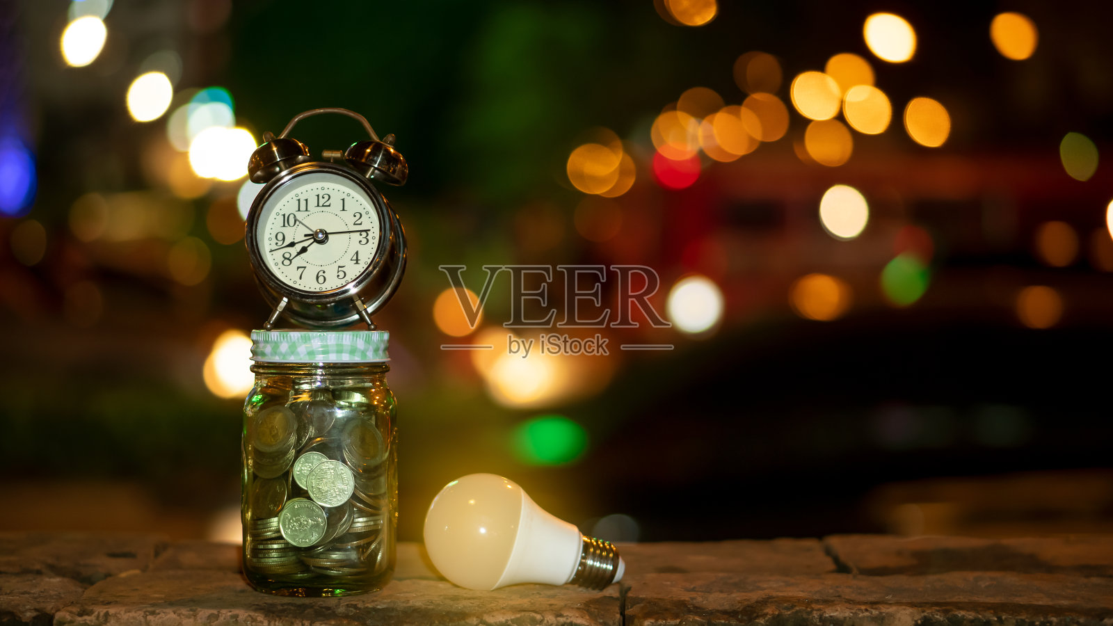 理财的长期存钱观念，存钱罐，硬币，闹钟和灯泡的复利投资意识照片摄影图片