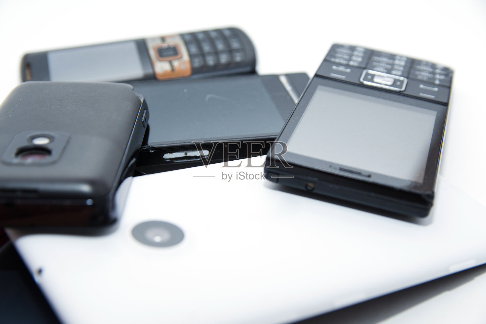 一堆旧的没用的，不工作的，肮脏的，满是灰尘和生锈的手机。不合理消费和消费主义观念。环境污染的概念。照片摄影图片