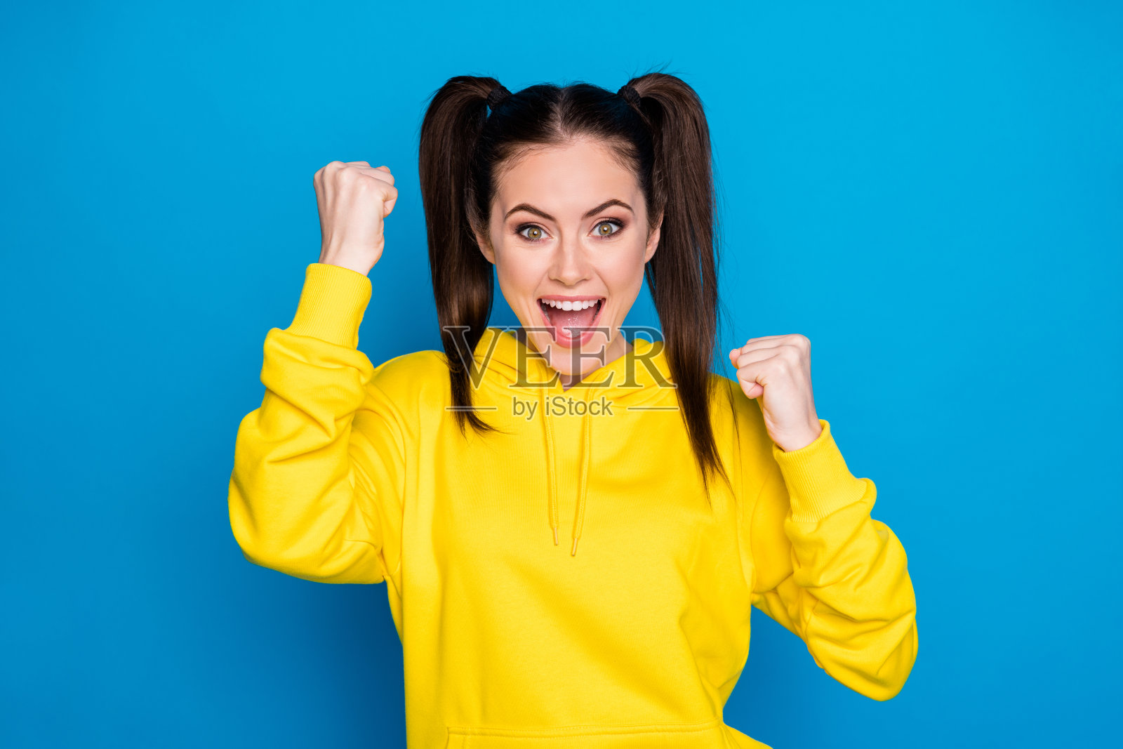 她的特写肖像，她很好，有吸引力，可爱的，漂亮的，可爱的，可爱的，讨人喜欢的，愉快的，高兴的，高兴的，幸运的棕色头发的女孩，高兴的，有乐趣的，在明亮生动的照耀，明亮的蓝色背景照片摄影图片