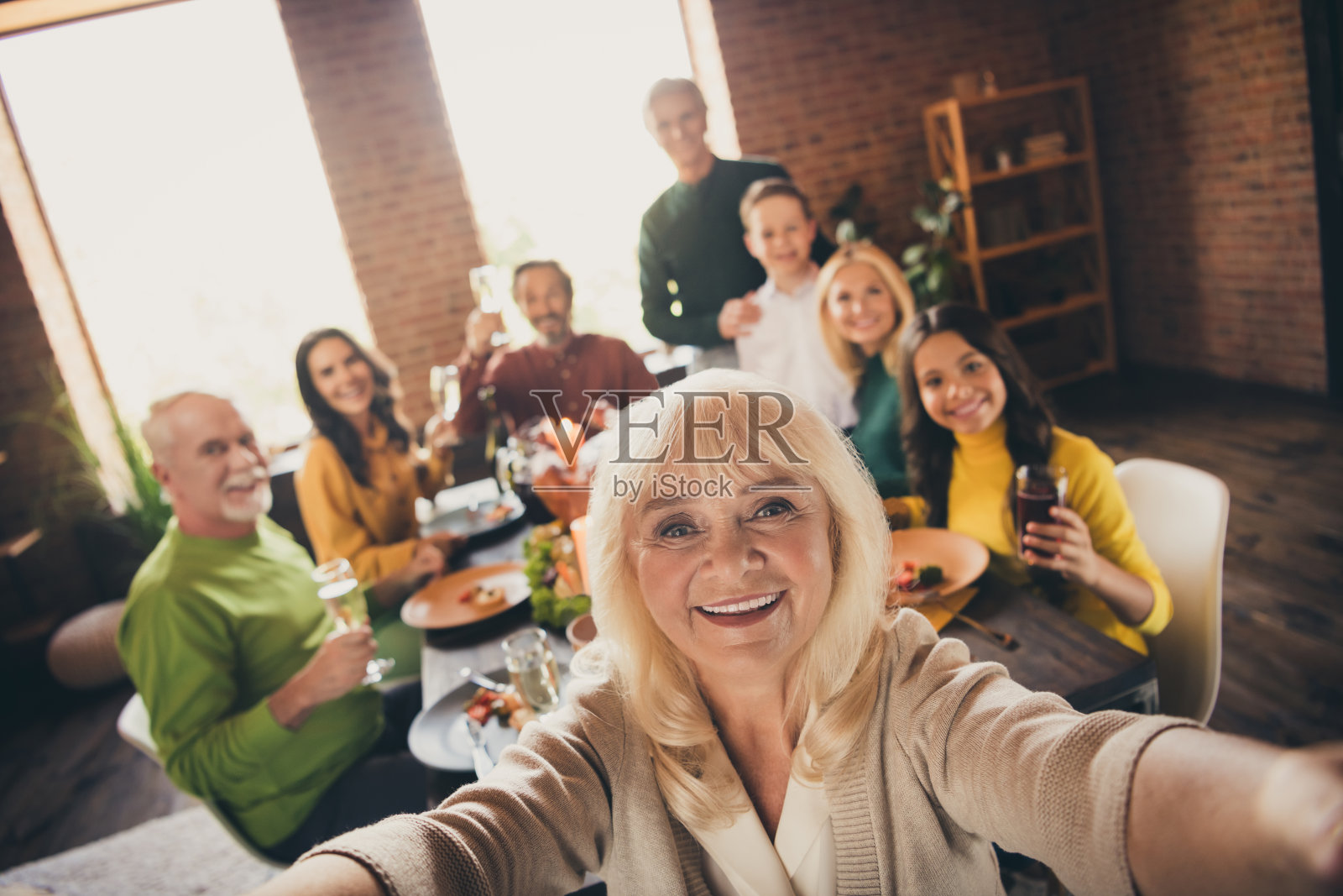 漂亮迷人的大家族的自画像，兄弟姐妹聚集父母，祖父母，孙辈吃自制的午餐节日的秋天习俗在现代阁楼砖工业室内照片摄影图片