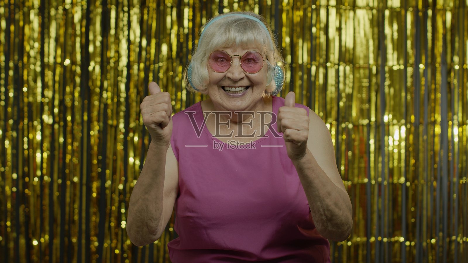 老女人跳舞，戴着耳机听音乐。放松，享受，开心，微笑照片摄影图片