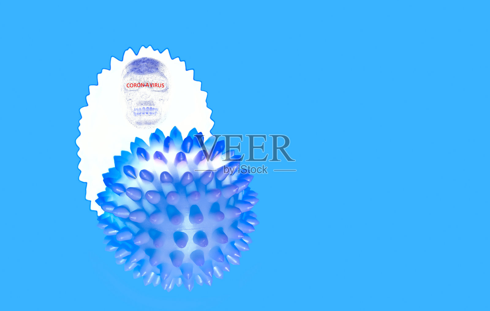 冠状病毒的抽象图像。一个蓝色的尖球和它的白色阴影与一个头骨的剪影和危险警告文本位于蓝色背景。照片摄影图片