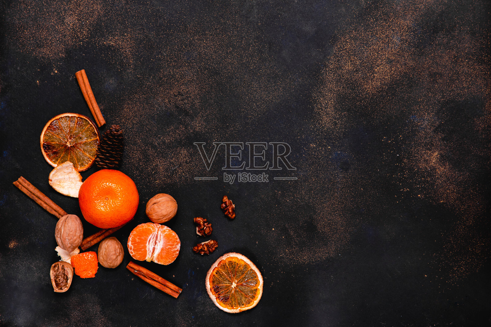 圣诞贺卡模型与橙子，桔子，坚果和肉桂棒在黑暗的背景。新年插图与文字空间俯视图照片摄影图片