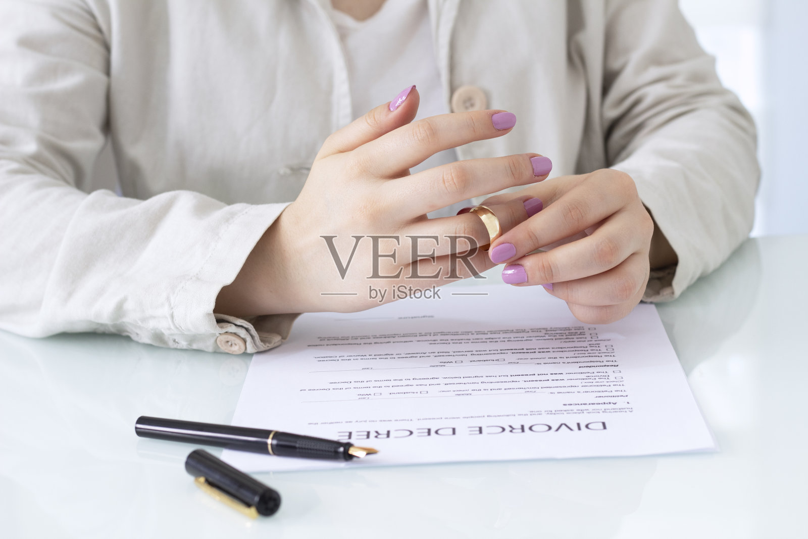 妻子、丈夫签署离婚令、解除婚约、取消婚姻、合法分居文件、提交由律师准备的离婚文件或婚前协议。结婚戒指照片摄影图片